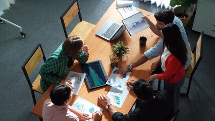 Naklejka premium Top view of project manager present financial graph to investors at meeting. Professional marketing team brainstorming financial idea while looking at financial statistic from laptop. Convocation.