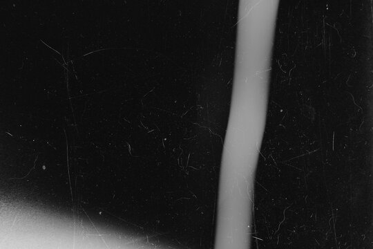 Dark grunge background texture with vertical light streak dust and film scratches
