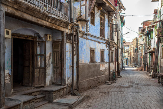 Historic residential alley in Bhavnagar with traditional blue facades.