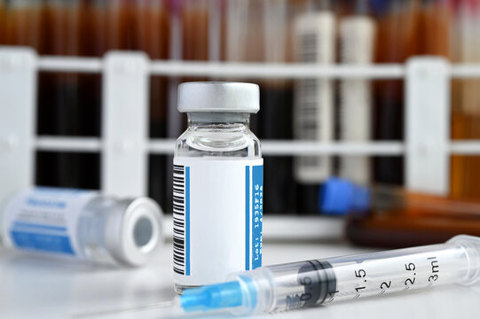A syringe needle with generic vaccine booster vial with blank label - mock up copy space