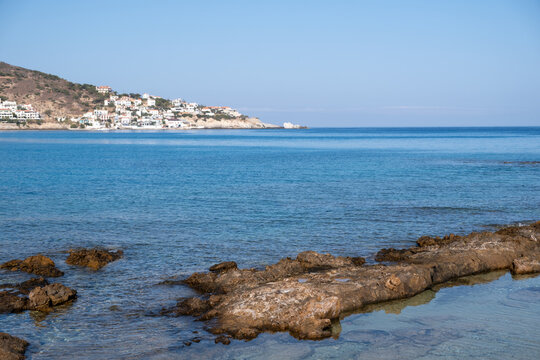 Armenistis village and bay in Ikaria island, Greece. Hillside houses, blue Aegean sea water, sunny summer day.