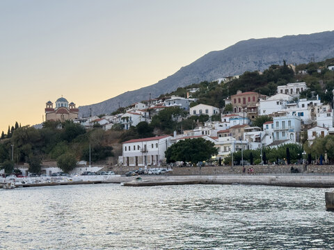 Agios Kirykos harbor waterfront with white hillside houses at blue hour, Ikaria island. Greece