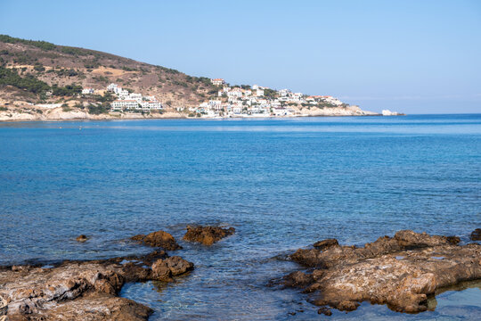 Armenistis village and bay in Ikaria island, Greece. Hillside houses, blue Aegean sea water, sunny summer day.