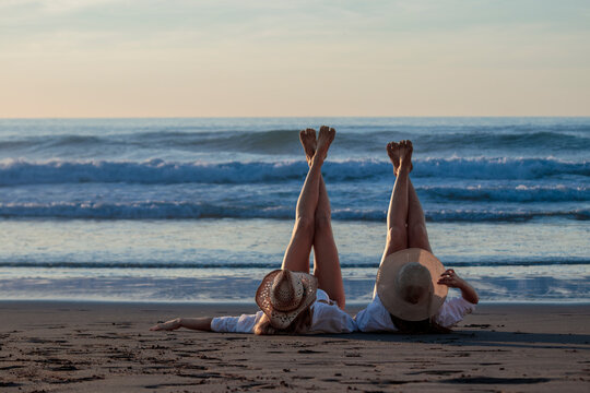 Friends relaxing with legs up on beach vacation