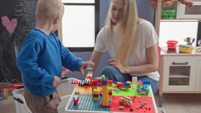 Woman places colorful blocks while boy's hand stacks bricks at building; nurturing learning playtime.