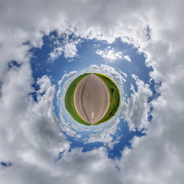 simple little tiny planet without buildings in blue sky with sun and beautiful clouds. Transformation of spherical panorama 360 degrees. Spherical abstract aerial view. Curvature of space.