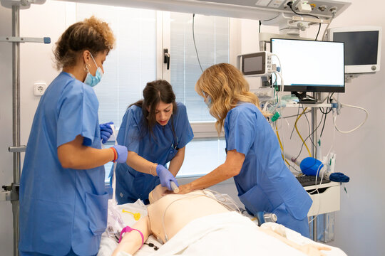 Medical students practicing cpr on training mannequin in simulation lab