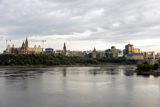 Ottawa skyline view across Ottawa River with Parliament Buildings. Canadian capital city panorama under overcast sunset sky