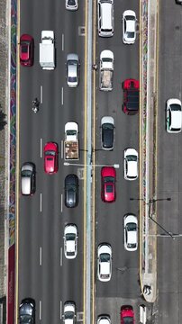 Vertical aerial top-down close-up of heavy traffic on the Viaducto in Mexico City, drone hovering at low altitude showing detailed cars flowing along the Viaducto avenue