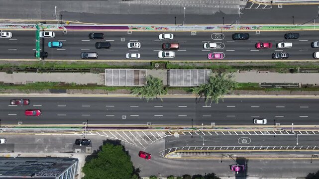 Aerial top-down view of the drone hovering over the Viaducto and Ecoducto in Mexico City with traffic flowing along the multi-lane avenue and green median