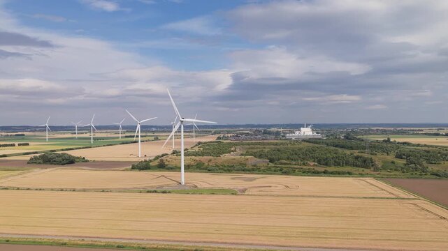 Wind Farm Generating Clean Power in Rural Golden Fields on a Partly Cloudy Day