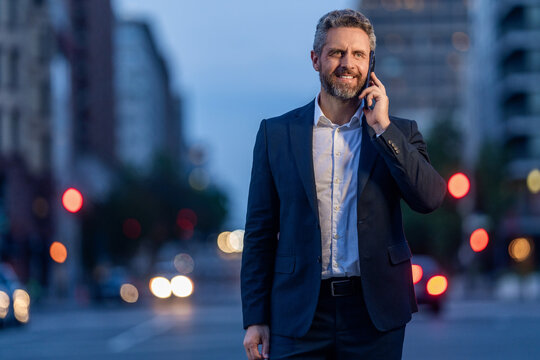 Businessman negotiation online, copy space. Man phone conversation in suit. Mature Hispanic business man with phone. Business communication of businessman. Business man talking on phone outdoor