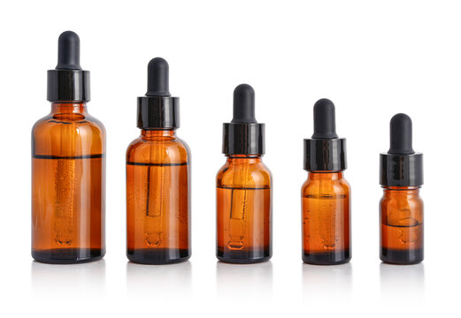 Five amber glass dropper bottles of different sizes isolated on white background with clipping path.