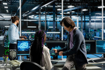 Obraz premium Server room manager teaching intern how to run AI prediction simulations, tracking performance.