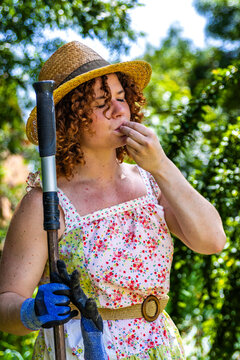 Woman farmer tasting fresh organic produce, cultivating sustainable practices in garden