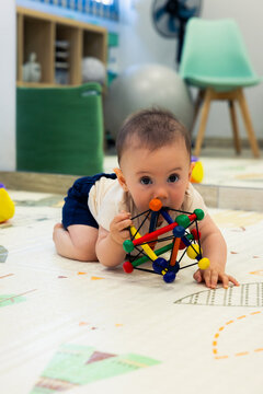 Baby playing with toy on playmat at daycare