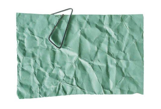 Hoja de papel verde menta arrugada con clip met&aacute;lico aislada sobre fondo negro, concepto de notas y organizaci&oacute;n