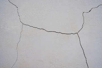 Fondo de pared blanca agrietada con textura de cemento envejecido y fisuras naturales © Manuela