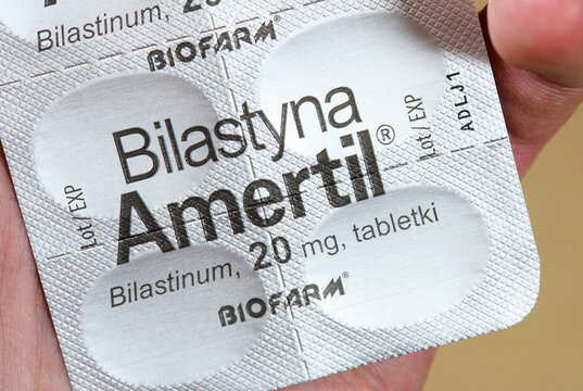 Bilastyna Amertil bilastinum 20 mg tablets in silver blister pack held in hand, macro closeup of Biofarm branded antihistamine allergy medicine packaging, Polish OTC pharmaceutical product, one person