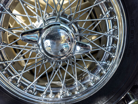 TAVERNES BLANQUES, SPAIN - JUNE 14, 2026.Detailed macro shot of shiny chrome wire wheel with central knock off spinner on classic British vintage car