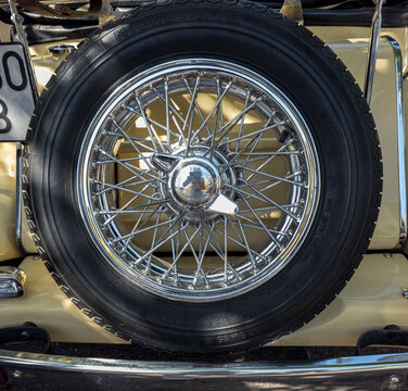 TAVERNES BLANQUES, SPAIN - JUNE 14, 2026.Rear view of vintage MG TD classic car showing spare wire wheel and chrome bumper in a parking area