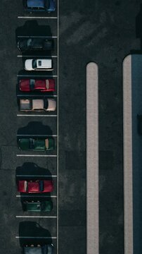 Cars are parked in a lot with clear lines. The scene shows different colors and types of cars positioned side by side. Sunlight covers the area and adds visibility.