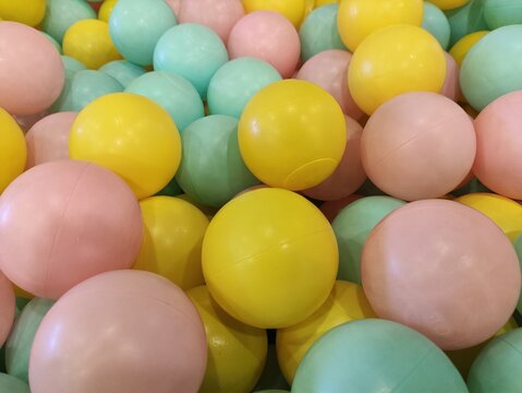 Colorful Pastel Ball Pit with Pink Yellow and Green Balls in Children Indoor Playground Photography