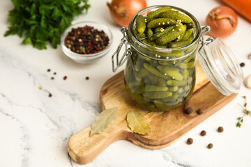 Fototapeta premium Jar with tasty pickled cucumbers and different spices on white background