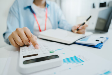 Fototapeta premium Office accountant using calculator with notebook and laptop for finance record keeping