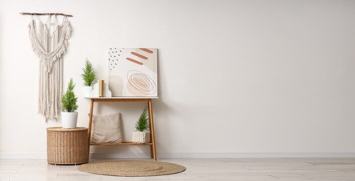 Boho chic interior design with macrame wall hanging, potted plants, and abstract art on a wooden shelf