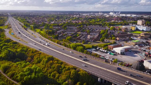 Drone photo of M4 motorway cutting through Slough, UK. Includes traffic, housing, farmland, and waterway&mdash;ideal for real estate, infrastructure, commuting, or transportation themes