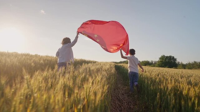 Happy Little Boys Chinese Patriots Children Runs With National China Flag. Countryside open area nature background. Celebration banner, holidays, Labour, Childrens Day, New Year.