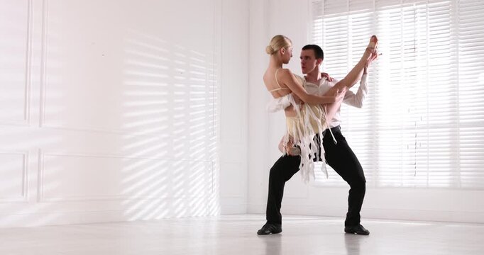 Couple of professional dancers training in studio
