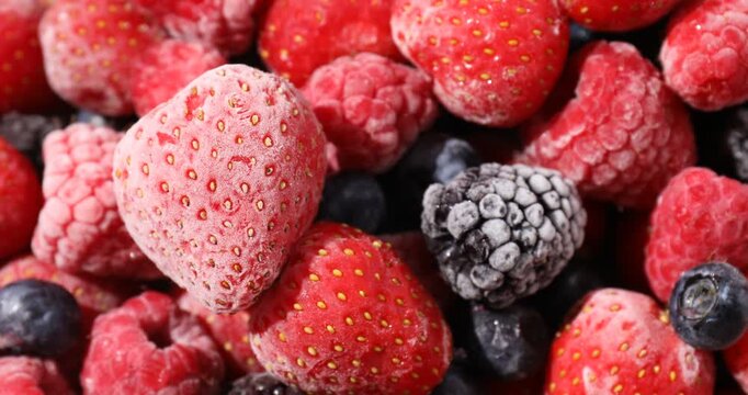 Mix of frozen berries as background, spinning. Closeup view