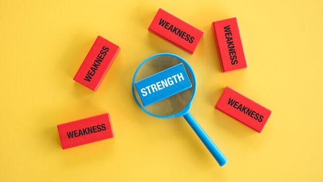 Magnifying Glass Zooming on Blue Strength Block Surrounded by Red Weakness Blocks