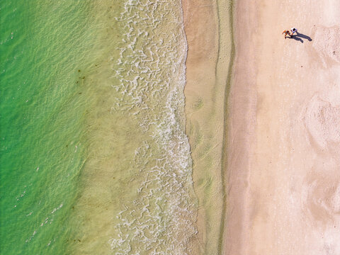 Aerial Drone View of Two People Walking Along Anna Maria Island Beach