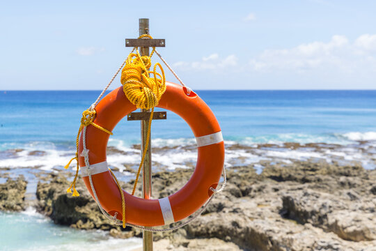 Orange lifebuoy by the tropical ocean