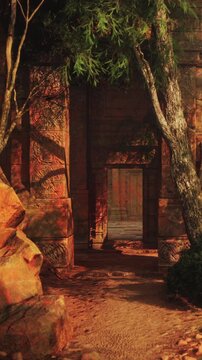 A pathway leads into a set of ancient ruins. Large rocks surround the area while trees provide shade. The scene captures the texture of old stone and natural surroundings.