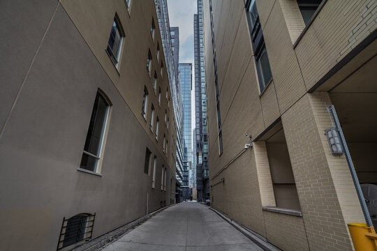North American Narrow service street between tall buildings in downtown Toronto, Ontario, showing CBD architecture, office towers and an corridor in a major North American economy hub in Canada