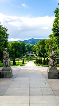 Statues Framing a Garden Pathway with Mountains in the Distance