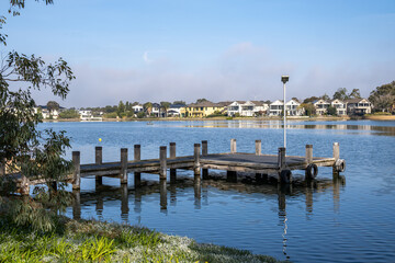 Fototapeta premium A lake and residential canal system within the master-planned estate of Sanctuary Lakes. Waterfront houses and luxury residential properties line the shoreline. Point Cook, Melbourne, Australia