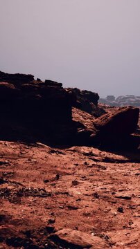 Rock formations cover the dry land with a gray sky above. The scene shows a rugged landscape with various rock shapes and textures. No vegetation is visible in this environment.
