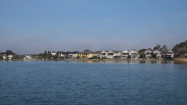 Waterfront homes line the far shore at Sanctuary Lakes, Point Cook. Melbourne, Australia. Concept of real estate, upscale suburban homes and premium lakeside living