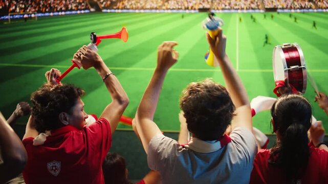 Soccer fans in red shirts react with excitement to goal scored during match for goal celebration, supporter emotion and fan culture content.