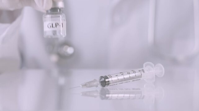 Glove on hand carefully holds GLP 1 hormone vial near sterile syringe, preparing medical weight management injection treatment therapy
