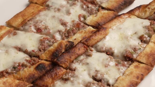 Delicious turkish pide with minced meat and grilled pepper served on a white plate