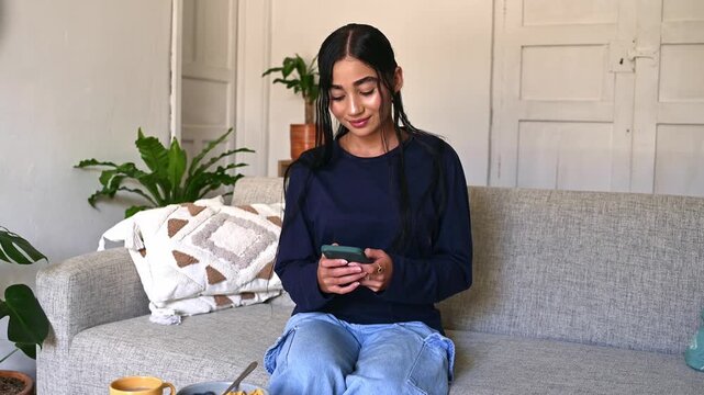 Young woman texting on smartphone at home