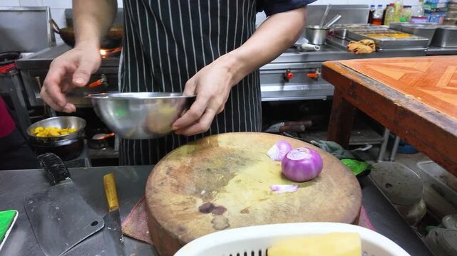 Professional Chef Slicing Red Onions on Wooden Board in Commercial Kitchen