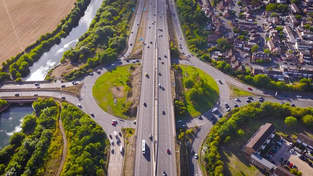 Drone photo of M4 motorway cutting through Slough, UK. Includes traffic, housing, farmland, and waterway&mdash;ideal for real estate, infrastructure, commuting, or transportation themes