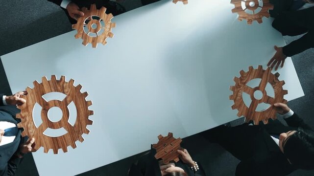 Top view of smart business people gather wooden cog together at meeting. Group of project manager helping and team working to solve problem at meeting room or workplace. Represent unity. Directorate.